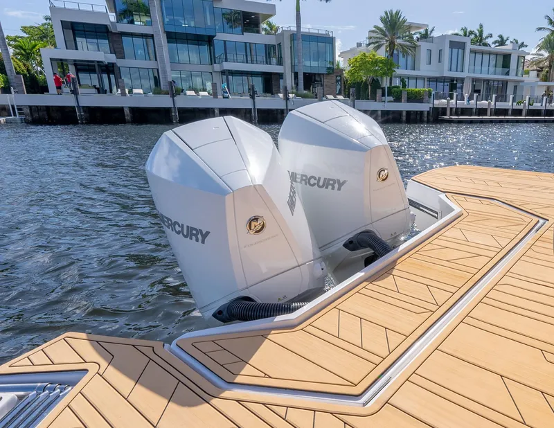 Slide: The Image of 2025 Hanover 347 Outboard boat with dual Mercury engines on a sunny waterfront. - 4