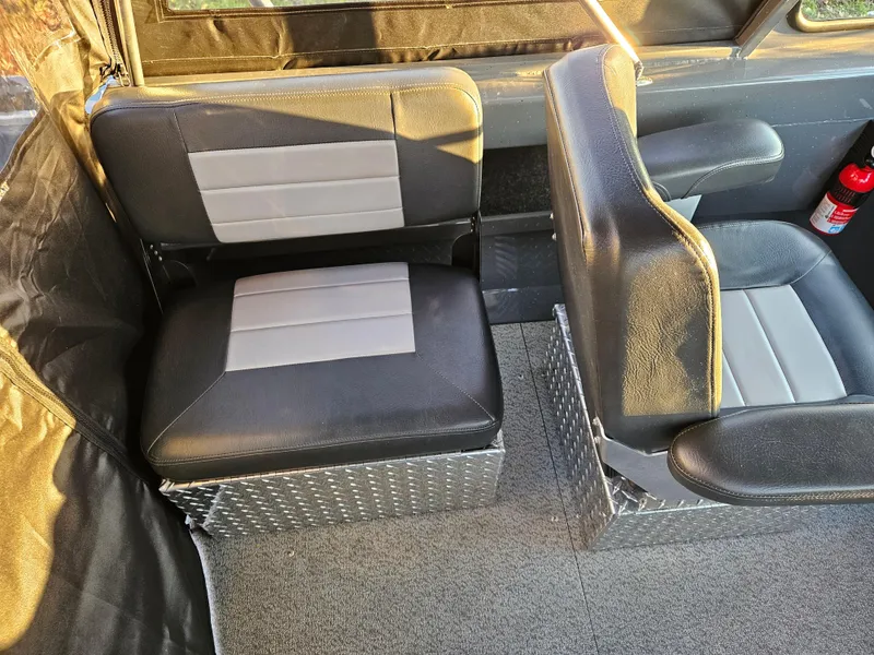 Slide: The Image of 2023 RH Boats 18 Sport interior with black and gray seating, fire extinguisher visible. - 16