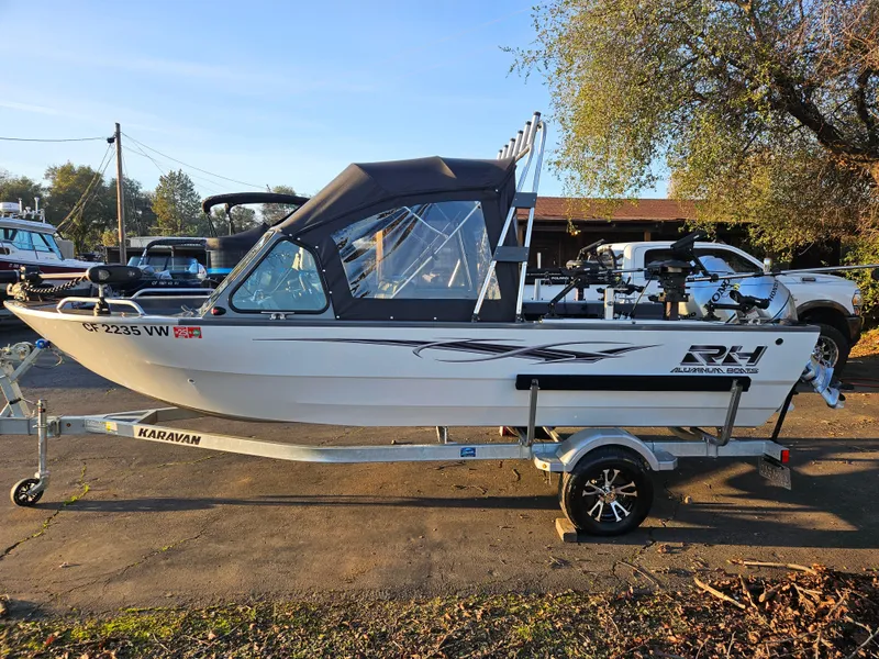 Slide: The Image of 2023 RH Boats 18 Sport on trailer, parked outdoors. - 2