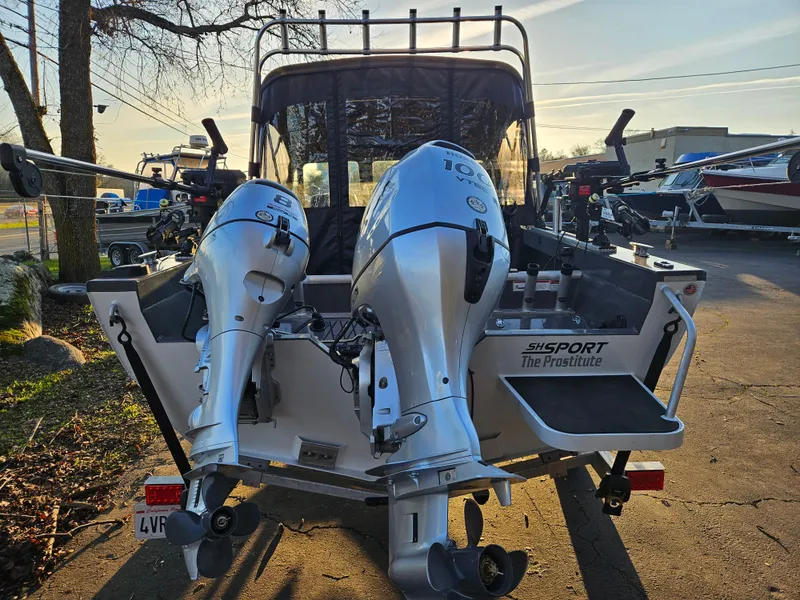 Slide: The Image of 2023 RH Boats 18 Sport with dual outboard motors in a marina setting. - 3