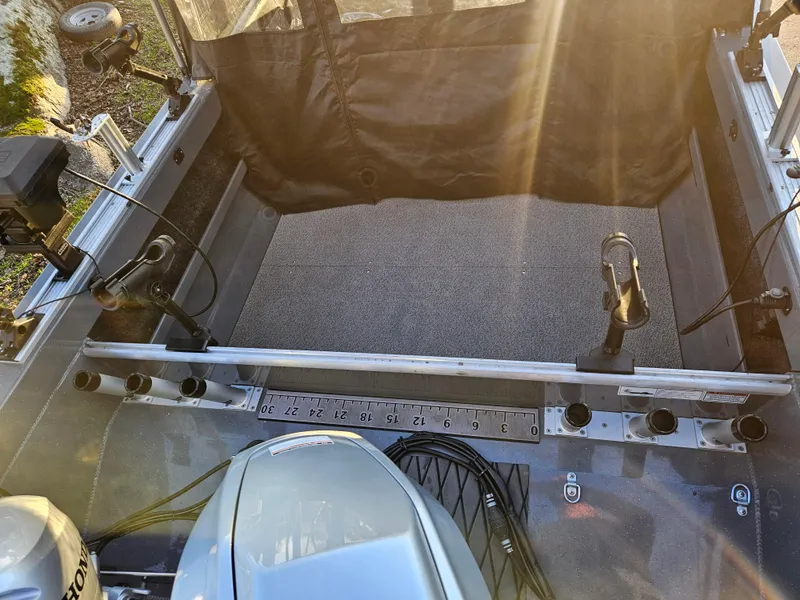 Slide: The Image of 2023 RH Boats 18 Sport interior with fishing rod holders and motor. - 7