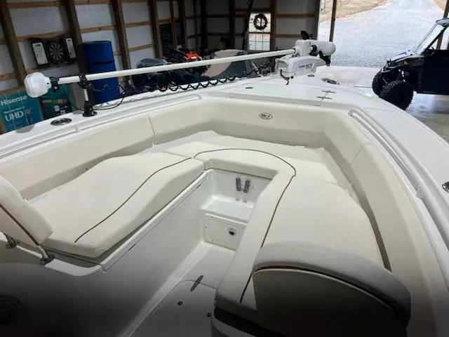 Slide: The Image of 2022 Sea Hunt Ultra 255 SE boat interior with white seating in a garage. - 2