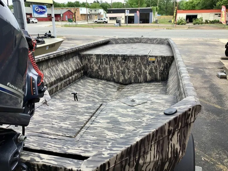 Slide: The Image of 2025 Reaper Boats 656 with camouflage design, parked outdoors near a boat dealership. - 13