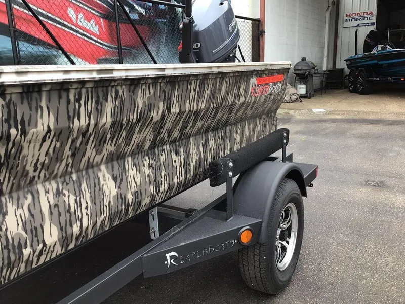 Slide: The Image of 2025 Reaper Boats 656 with camouflage design on a trailer at Honda Marine. - 17