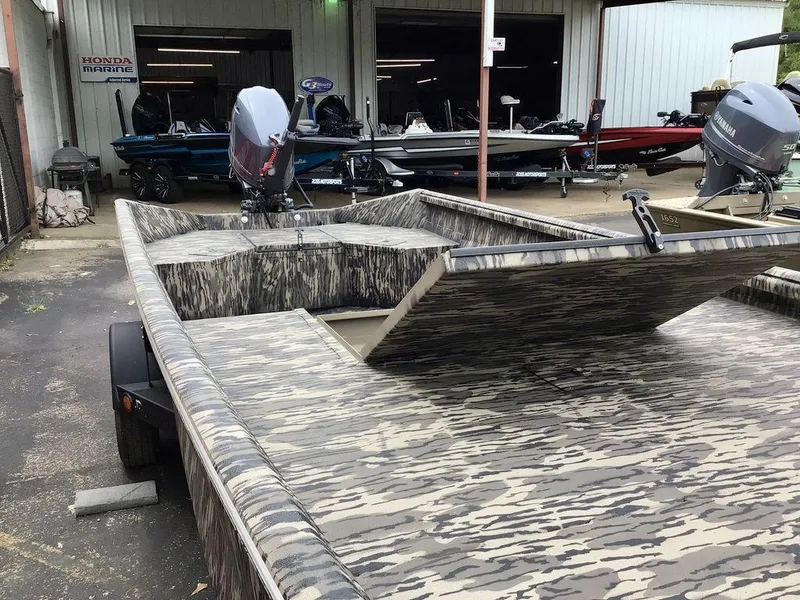 Slide: The Image of 2025 Reaper Boats 656 with camouflage design, parked outside a marine shop. - 20