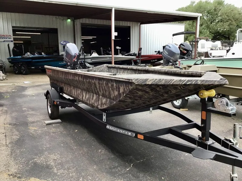 Slide: The Image of 2025 Reaper Boats 656 on trailer, camo design, parked outside a marine shop. - 8