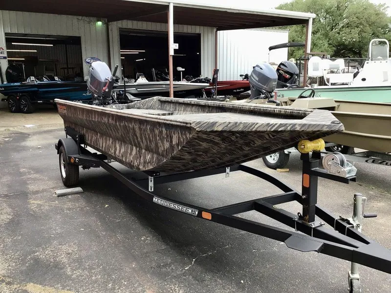 Slide: The Image of 2025 Reaper Boats 656 on trailer, camo design, parked outside a boat dealership. - 9