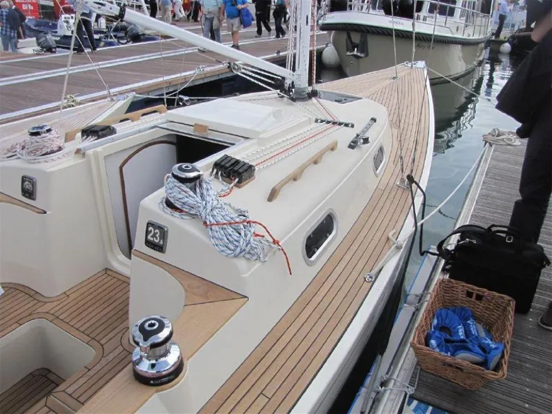 Slide: The Image of 2025 Rustler 33 sailboat docked, featuring sleek wooden deck and modern design. - 10