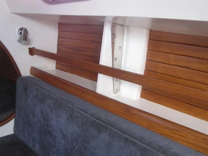 Slide: The Image of Interior of 2025 Rustler 33 yacht with wooden paneling and cushioned seating. - 17