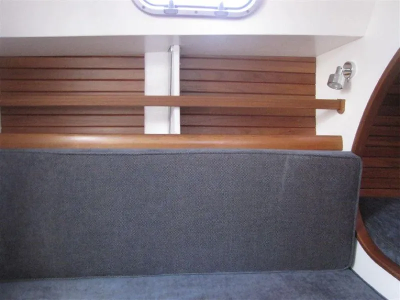 Slide: The Image of Interior of 2025 Rustler 33 yacht with wooden paneling and cushioned seating. - 18