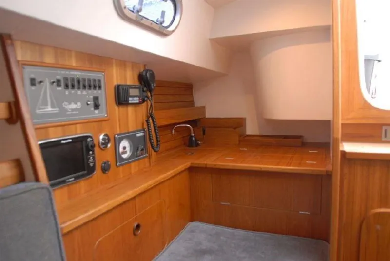 Slide: The Image of 2025 Rustler 33 yacht interior with navigation equipment and wooden finish. - 19