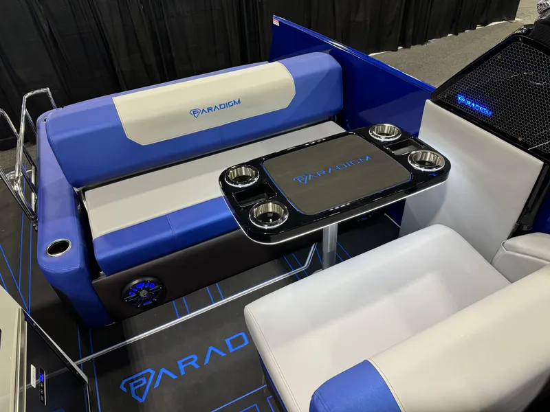 Slide: The Image of Paradigm 236 boat interior, 2025 model, featuring blue and white seating with a central table. - 8