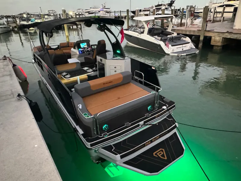Slide: The Image of 2025 Paradigm Damascus 260 Surf boat docked with illuminated green underwater lights. - 12