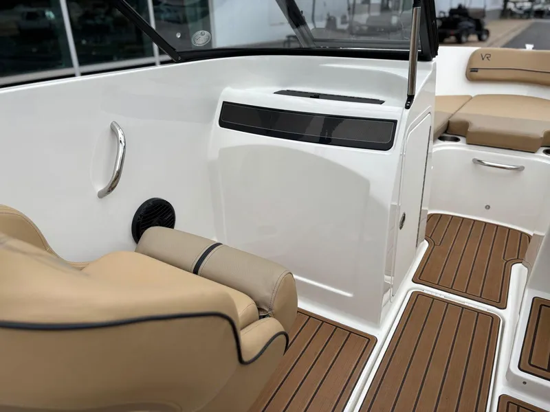 Slide: The Image of 2023 Bayliner VR4 boat interior with tan seating and wood-style flooring. - 10