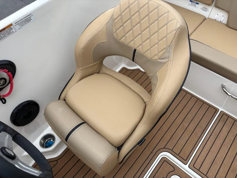 Slide: The Image of 2023 Bayliner VR4 boat interior with tan cushioned seat and wood-patterned flooring. - 11