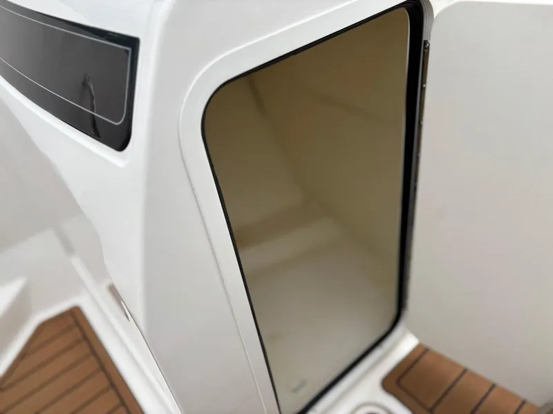 Slide: The Image of 2023 Bayliner VR4 boat interior storage compartment with open door, featuring sleek design. - 12