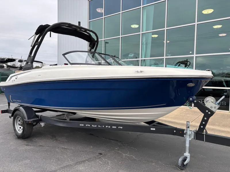Slide: The Image of 2023 Bayliner VR4 boat on trailer, blue and white exterior, parked outside showroom. - 2
