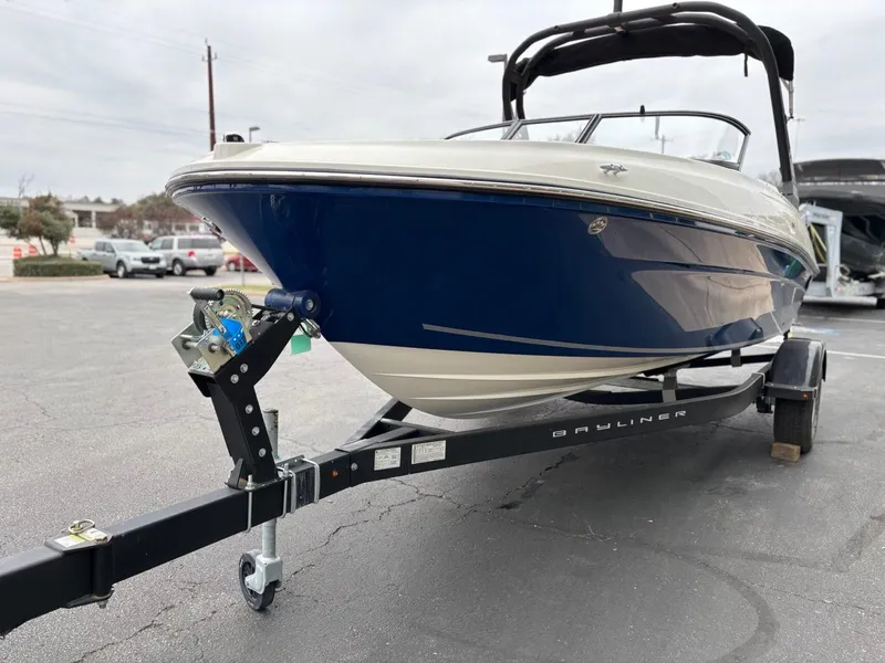Slide: The Image of 2023 Bayliner VR4 boat on trailer, parked outdoors, showcasing sleek design. - 3
