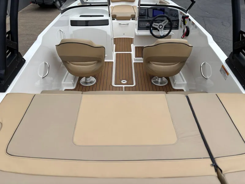 Slide: The Image of 2023 Bayliner VR4 boat interior with tan seats and wood-style flooring. - 5