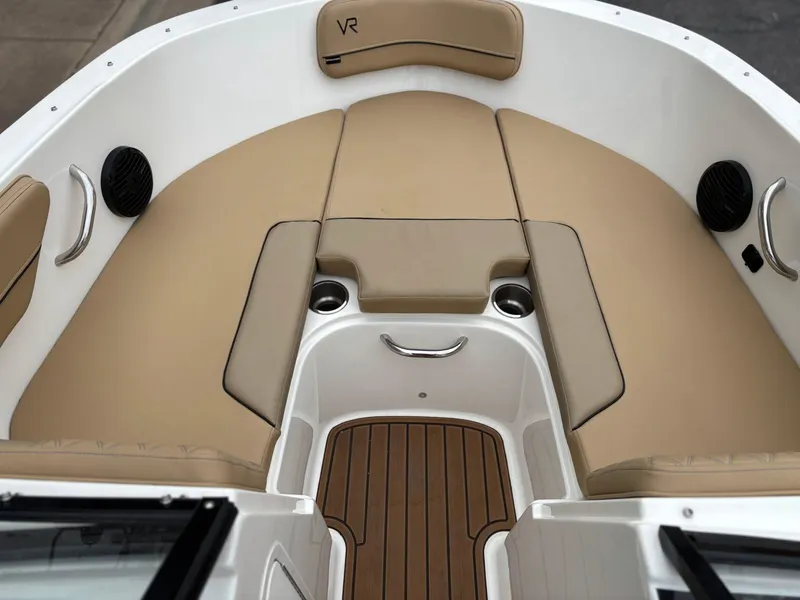 Slide: The Image of 2023 Bayliner VR4 boat interior with tan seating and wood-style flooring. - 6