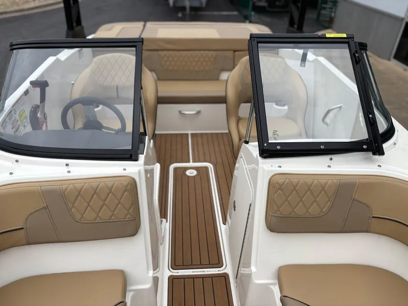 Slide: The Image of 2023 Bayliner VR4 boat interior with tan seating and wood-style flooring. - 8