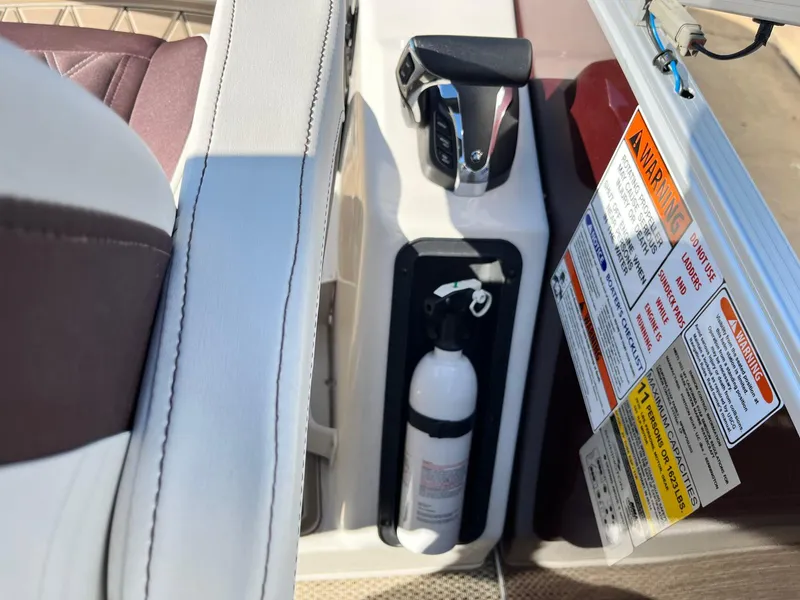 Slide: The Image of 2023 Bennington 23Q boat interior with control panel, fire extinguisher, and safety warnings. - 22