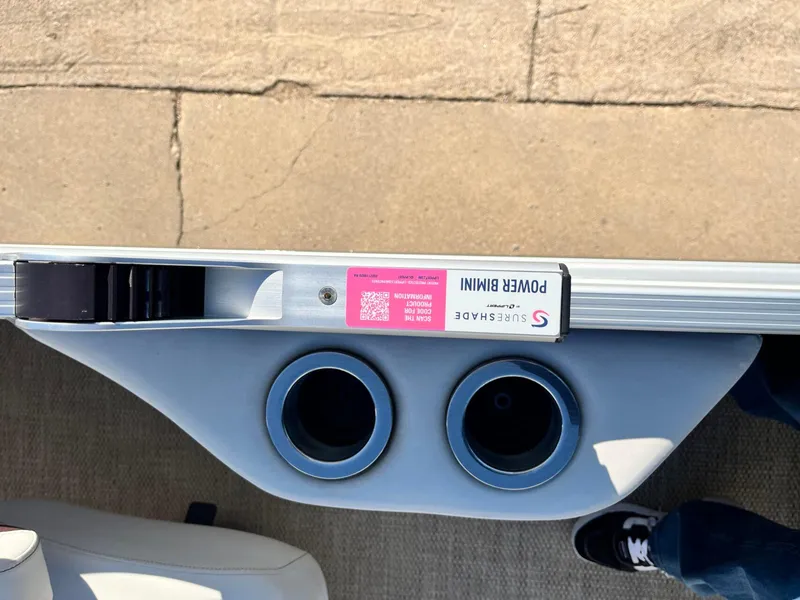 Slide: The Image of 2023 Bennington 23Q boat with SureShade Power Bimini and dual cup holders. - 23