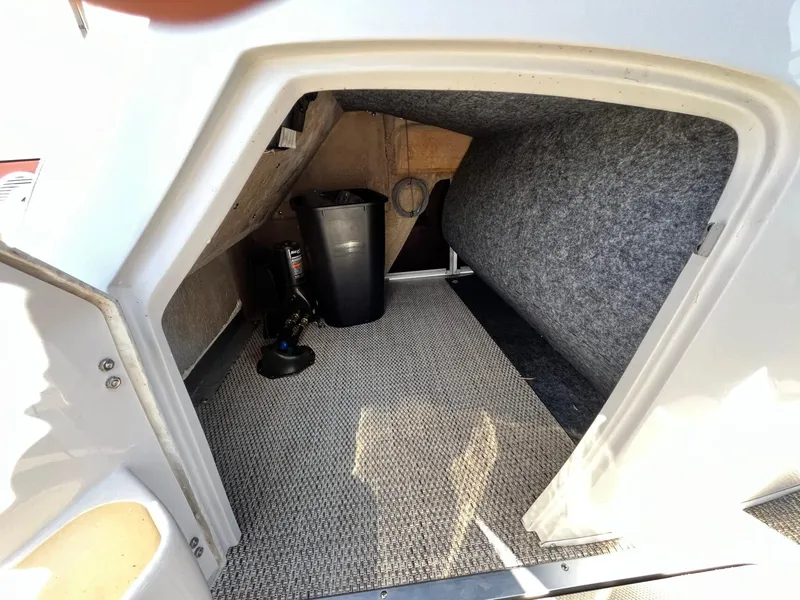 Slide: The Image of Interior storage compartment of 2023 Bennington 23Q boat, featuring carpeted flooring and equipment. - 27