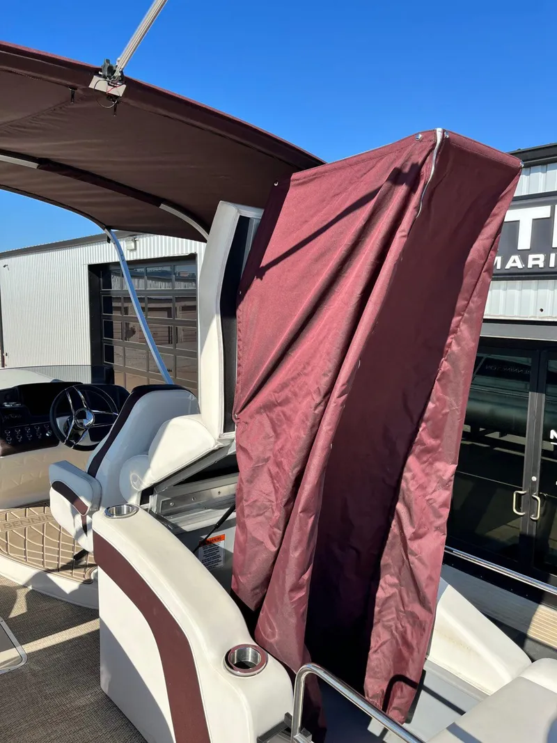 Slide: The Image of 2023 Bennington 23Q boat interior with maroon privacy curtain and steering wheel. - 32