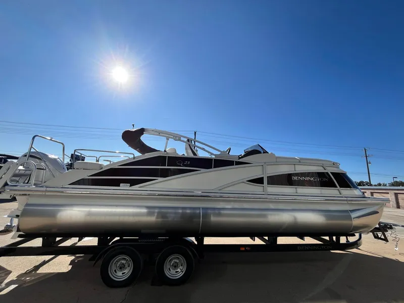 Slide: The Image of 2023 Bennington 23Q pontoon boat on trailer under bright sun. - 6