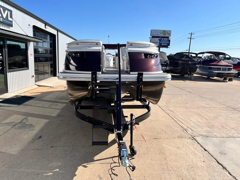 Slide: The Image of 2023 Bennington 23Q pontoon boat on trailer at dealership under clear blue sky. - 7