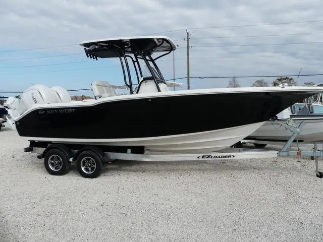 Slide: The Image of 2025 Key West 244 CC boat on trailer, featuring dual engines and sleek black design. - 4