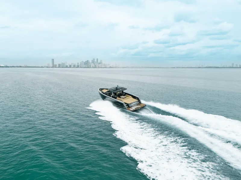 Slide: The Image of Fjord 52 Open 2022 cruising on open water with city skyline in background. - 8