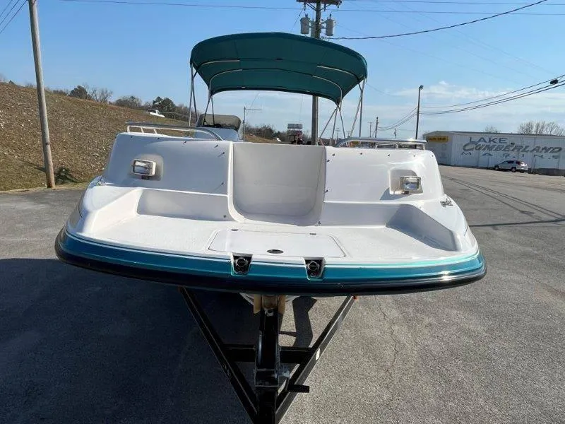 Slide: The Image of 1996 Chaparral Sunesta 250 boat with teal trim and canopy on a trailer. - 12