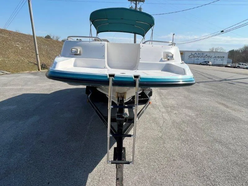 Slide: The Image of 1996 Chaparral Sunesta 250 boat on trailer, front view, with teal accents and canopy. - 38