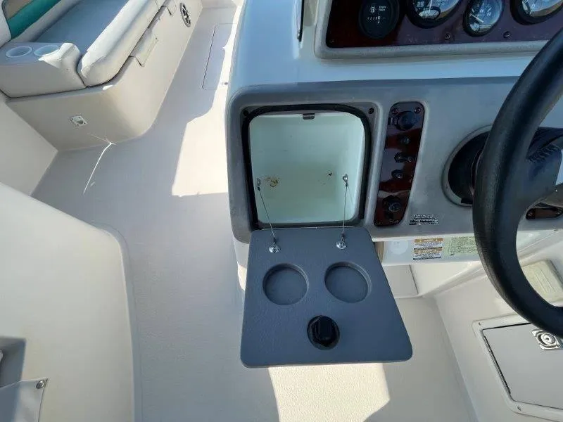 Slide: The Image of 1996 Chaparral Sunesta 250 boat interior with open storage compartment and cup holders. - 45