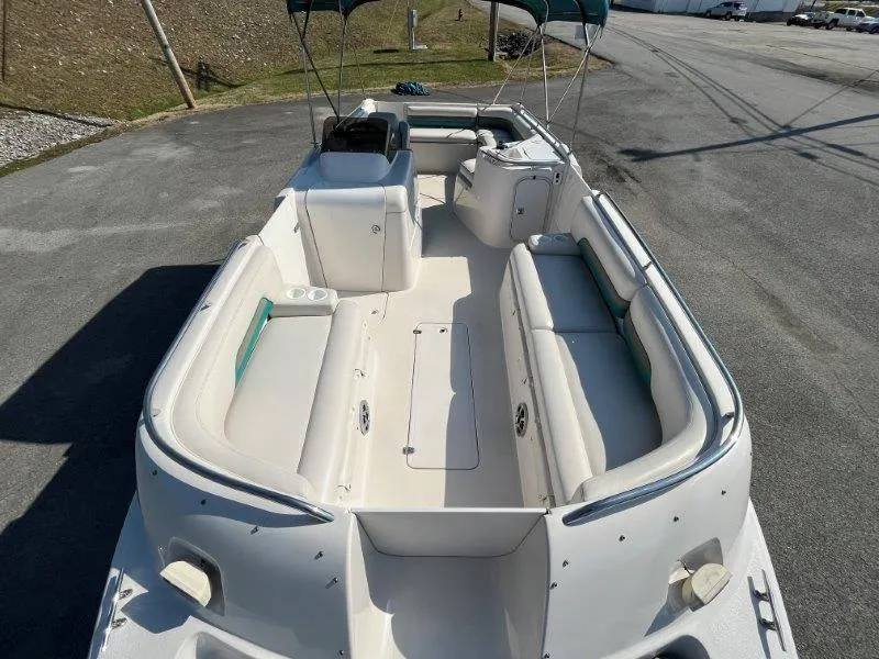 Slide: The Image of 1996 Chaparral Sunesta 250 boat with spacious seating and canopy, parked on pavement. - 46