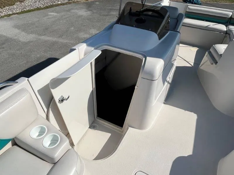 Slide: The Image of 1996 Chaparral Sunesta 250 boat interior with open cabin door and seating area. - 47