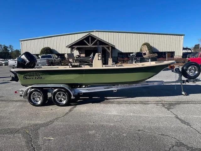 The Image of 2025 Carolina Skiff E20 JVX boat on trailer, parked outside a building. - 0