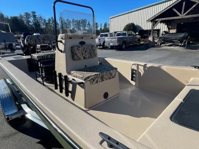 Slide: The Image of 2025 Carolina Skiff E20 JVX boat with camouflage seating, parked outdoors. - 4