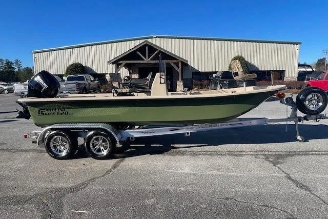 Slide: The Image of 2025 Carolina Skiff E20 JVX boat on trailer, parked outside a building. - 8