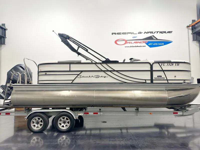 Slide: The Image of 2022 South Bay 222RS pontoon boat on trailer in showroom. - 0
