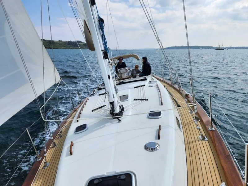 Slide: The Image of 2025 Rustler 37 sailboat cruising on open water with crew onboard. - 10