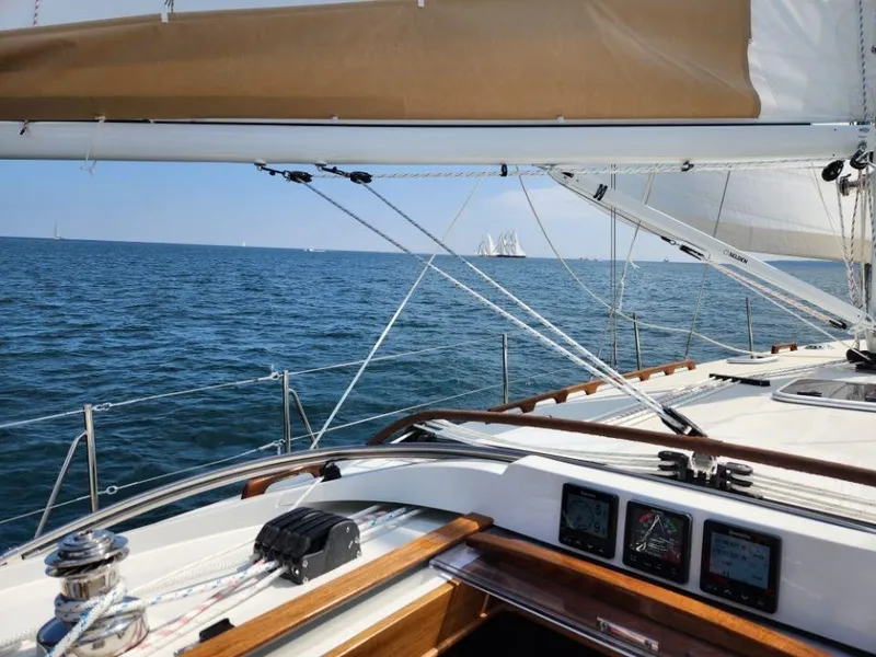 Slide: The Image of 2025 Rustler 37 sailboat on open sea, clear skies, visible sails and navigation instruments. - 13