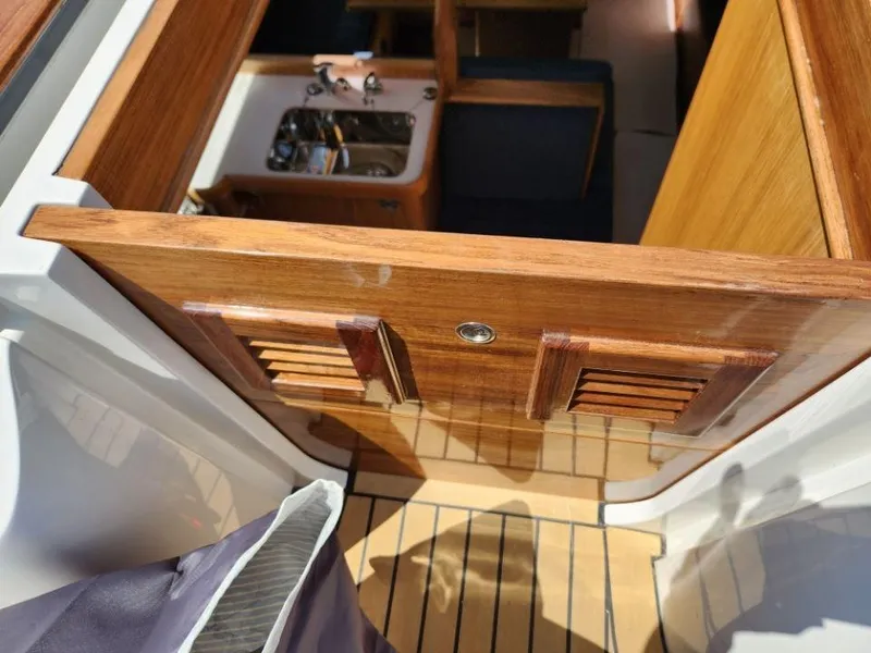 Slide: The Image of Interior view of 2025 Rustler 37 yacht, featuring wooden cabinetry and compact sink area. - 14