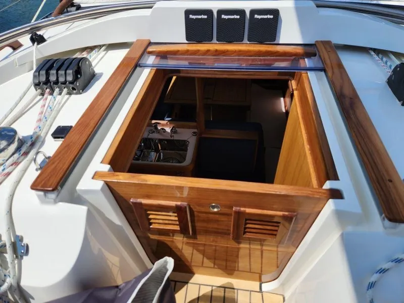 Slide: The Image of 2025 Rustler 37 yacht cockpit with open wooden hatch and visible interior. - 15