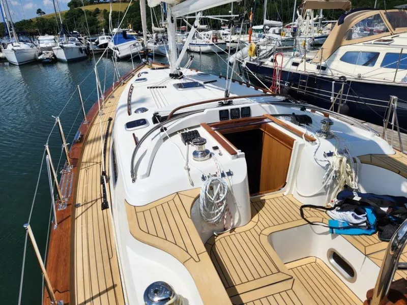 Slide: The Image of 2025 Rustler 37 sailboat with teak deck, docked in a marina. - 16