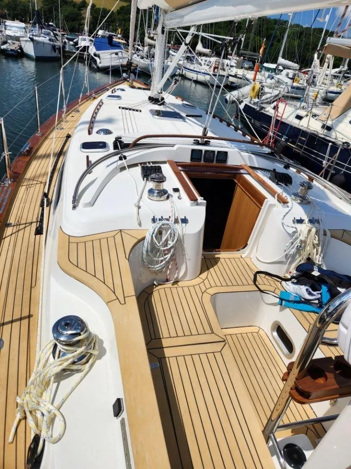 Slide: The Image of 2025 Rustler 37 yacht with teak deck, docked in a marina. - 17