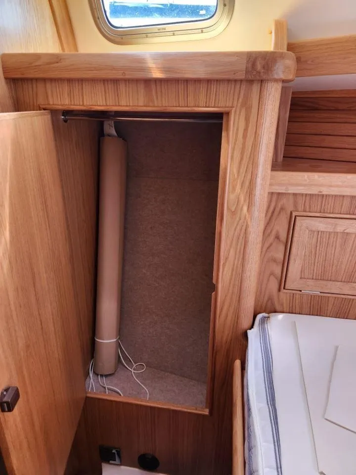 Slide: The Image of Rustler 37 (2025) yacht interior with wooden cabinetry and storage compartment. - 21
