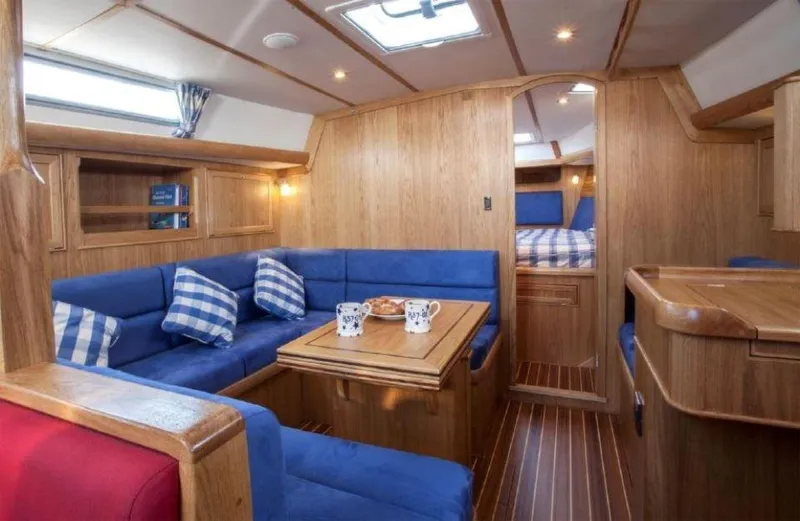 Slide: The Image of Luxurious interior of 2025 Rustler 37 yacht with blue seating and wooden finishes. - 22